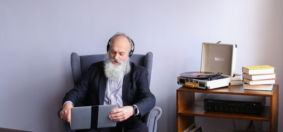 Alter Mann mit Computer und Plattenspieler