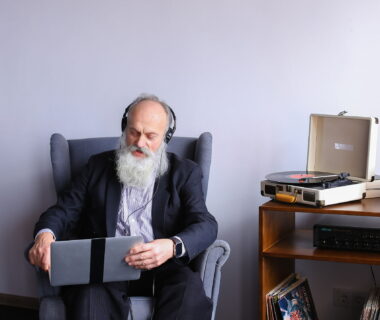 Alter Mann mit Computer und Plattenspieler